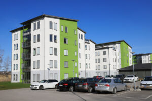 Modern multi-storey residential buildings and parking space in the front with cars