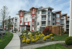 Multi-family housing architecture featuring a courtyard with luscious landscapes.