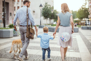 A family with their dog walking outside their apartment - the convenience of a multi-family architecture