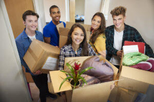 Group of students carrying boxes with their things as they move into their dormitories.