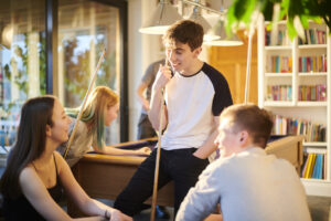 College students playing billiards in their student housing - adding amenities to student housing architecture.