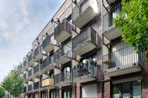 Exterior shot of a modern student dormitory surrounded by trees - modern student housing design.