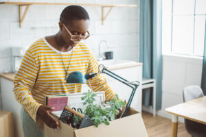 Female college student unpacking her belongings in her new room.