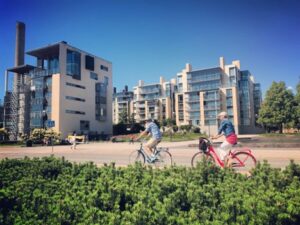 Designing multi-family developments - People riding their bikes in a park outside of their multi-family home.